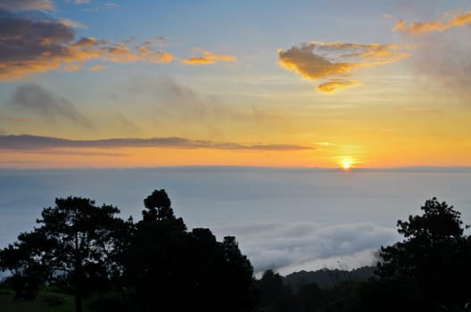 Colorful sunrise above the clouds from high mountain at viewpoint Huai Nam Dang national park in Chiang Mai and Mae Hong Son province of Thailand