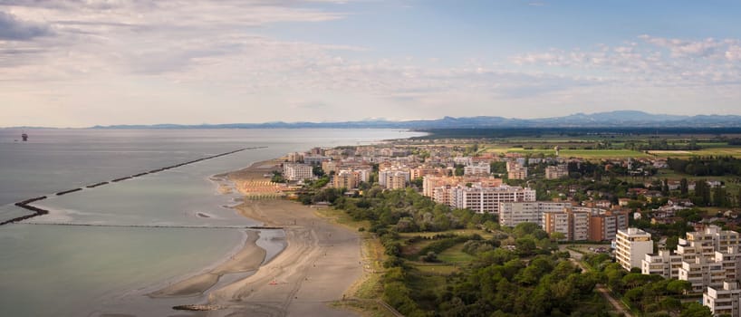 Drone shot of sandy beach with umbrellas and gazebos.Summer vacation concept.Lido Adriano town,Adriatic coast, Emilia Romagna,Italy.