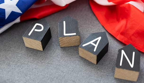 PLAN word on a wooden cubes on white grey glossy background with reflection. High quality photo