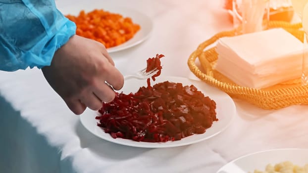 beetroot salad for tasting. hand with fork serving salad. public discussion of dishes.