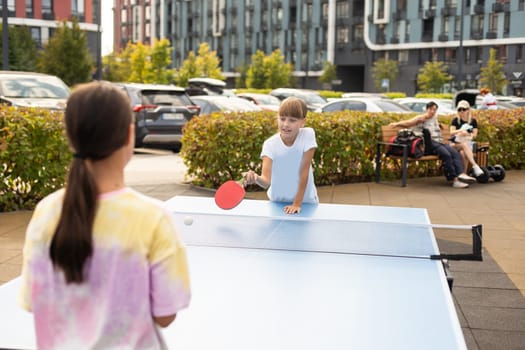 Little children playing ping pong in park. High quality photo