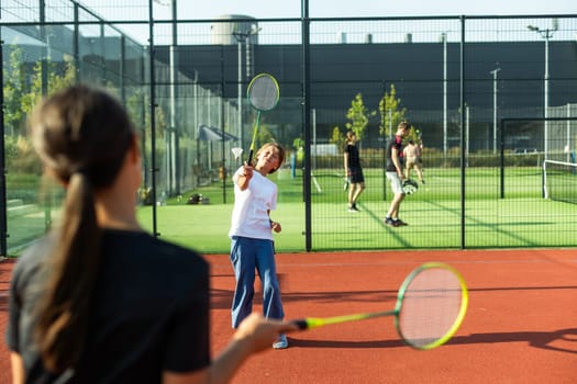 Two girls with badminton rackets on the football field. High quality photo