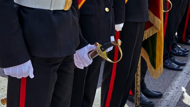 Military honor guard with sword and weapon. A white glove holds a saber for Independence Day.