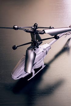 Gray toy helicopter on a wooden table close up