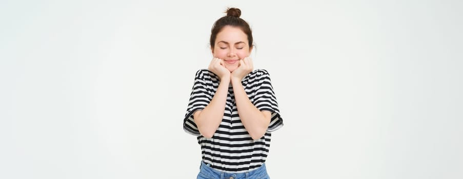 Portrait of beautiful, excited brunette woman, feeling excited and upbeat, smiling and looking happy, standing over white background.