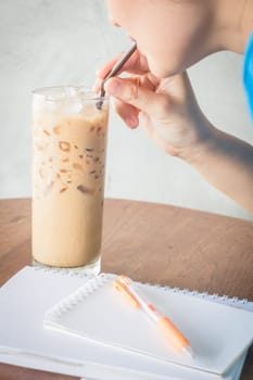 Woman drinking iced milk coffee, stock photo
