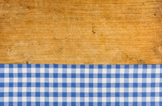 Rustic wooden background with a blue checkered tablecloth