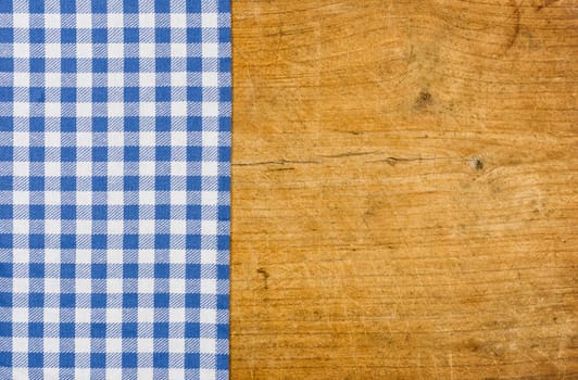 Rustic wooden background with a blue checkered tablecloth