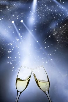 Glasses with champagne against fireworks and holiday lights