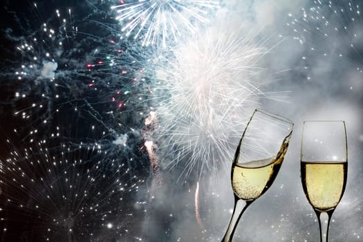 Glasses with champagne against fireworks and holiday lights