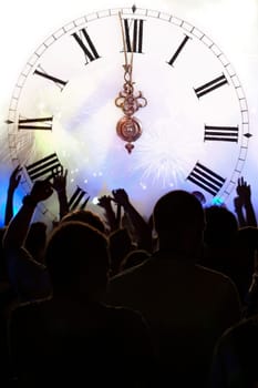 Clock close to midnight, fireworks and crowd waiting for New year