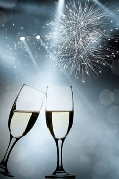 Glasses with champagne against fireworks and holiday lights