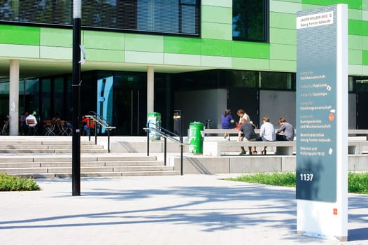 Mainz,Germany – August 09,2014: Students sit in front of the new and modern Georg Forster building on the grounds of Johannes Gutenberg University on August 9,2014 in Mainz.
