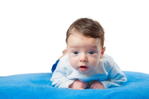 Beautiful baby boy sitting on his tummy on blue blanket.