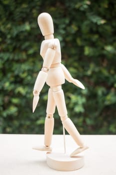 Wood artist mannequin pose walking on the table, stock photo