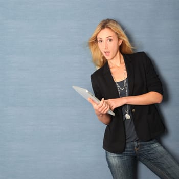 Beautiful woman leaning on wall with touchpad