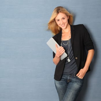 Beautiful woman leaning on wall with touchpad