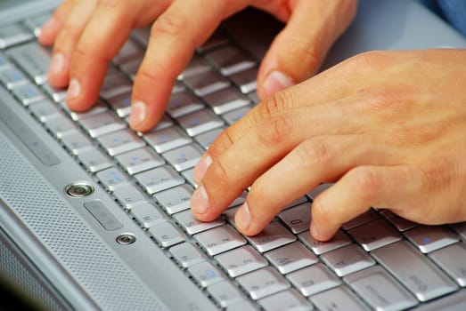 male hands typing on a laptop
