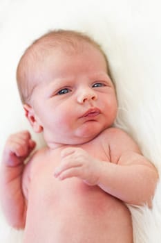Little baby toddler newborn naked on a white fur as Detal