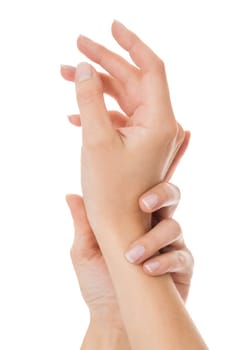 Sensual female hands of a woman with neat natural nails graceful keeps her wrist isolated on white with