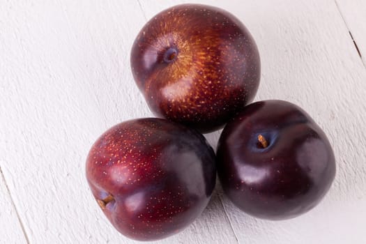 Fresh shiny juicy plums with ripe color with stem up as close-up