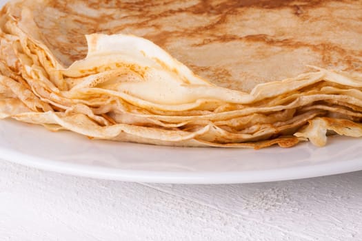 delicious fresh crepes pancakes pancakes on a white plate on a rustic white wooden board
