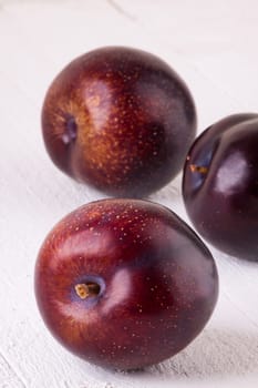 Fresh shiny juicy plums with ripe color with stem up as close-up