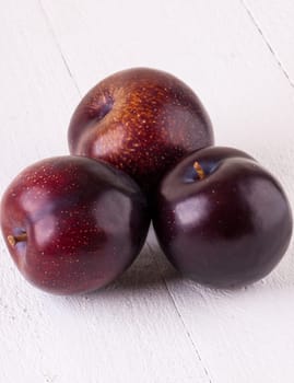 Fresh shiny juicy plums with ripe color with stem up as close-up