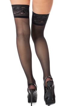 Sensual portrait of slender female legs in elegant stilettos and black stockings isolated on white background