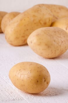 Fresh washed potatoes with peel as a close-up on a rustic wooden board