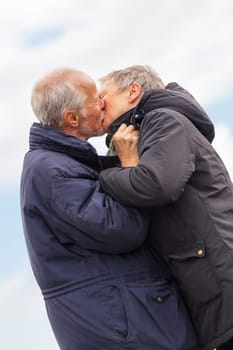 older adult happy couple walks on the beach in autumn lifestyle happiness
