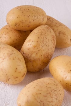 Fresh washed potatoes with peel as a close-up on a rustic wooden board
