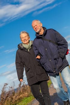 older happy couple makes a beach walk in autumn baltic sea landscape sea