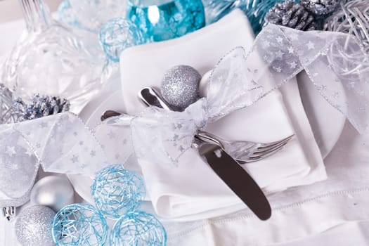 Stylish table with Christmas decoration in turquoise and silver shiny with cutlery