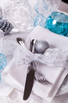 Stylish table with Christmas decoration in turquoise and silver shiny with cutlery