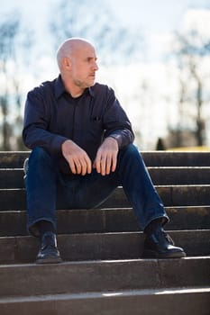 Man middle-aged senior pensioner taking a break in the outdoor park