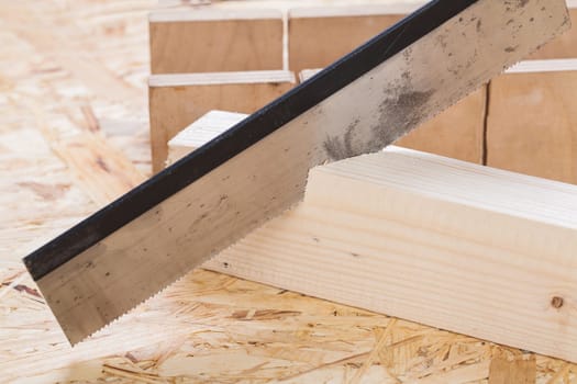 Wood with angle cutter and saw in a workshop close-up detail