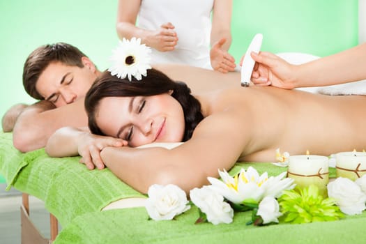 Young couple receiving microdermabrasion therapy at beauty spa with her man