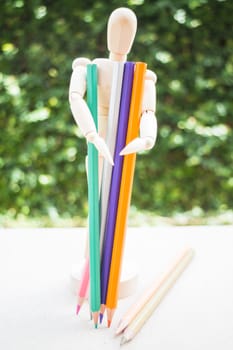 Wooden manikin and colour pencil on artist work table