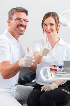 Female patient with dentist and dental assistant during treatment