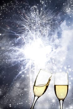 Glasses with champagne against fireworks and holiday lights