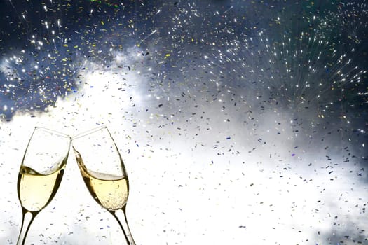 Glasses with champagne against fireworks and holiday lights