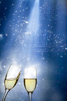 Glasses with champagne against fireworks and holiday lights