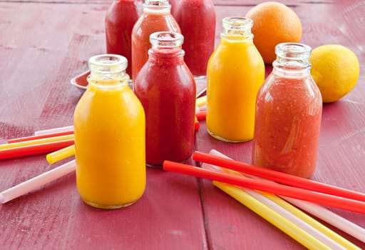 Smoothies from various fruits in small bottles