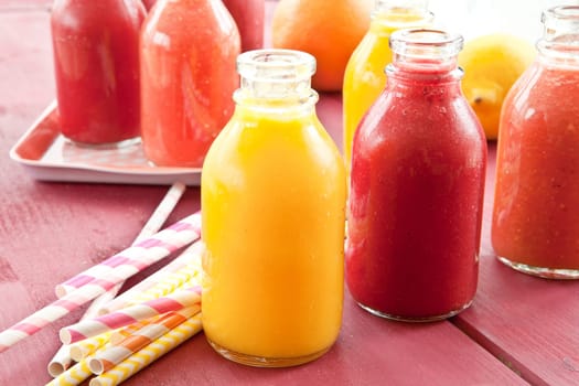 Smoothies from various fruits in small bottles
