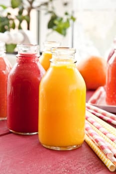 Smoothies from various fruits in small bottles