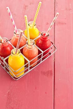 Smoothies from various fruits in small bottles