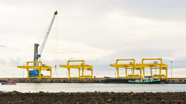 Crane for lifting a load up and down the ship in deep water harbor area of Thailand