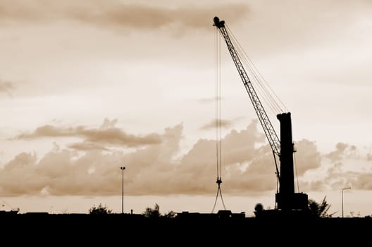 Harbor cranes silhouettes with sepia color..