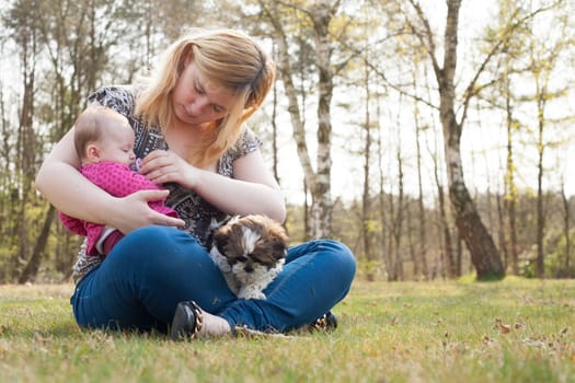 Mother is having a trip with the baby and dog outside